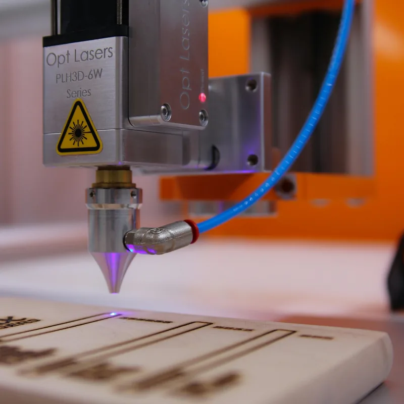 Lazerio galvutė tiksliai graviruoja medinį paviršių