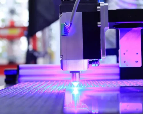 Lazerio galvutė graviruoja medžiagą violetinėje šviesoje